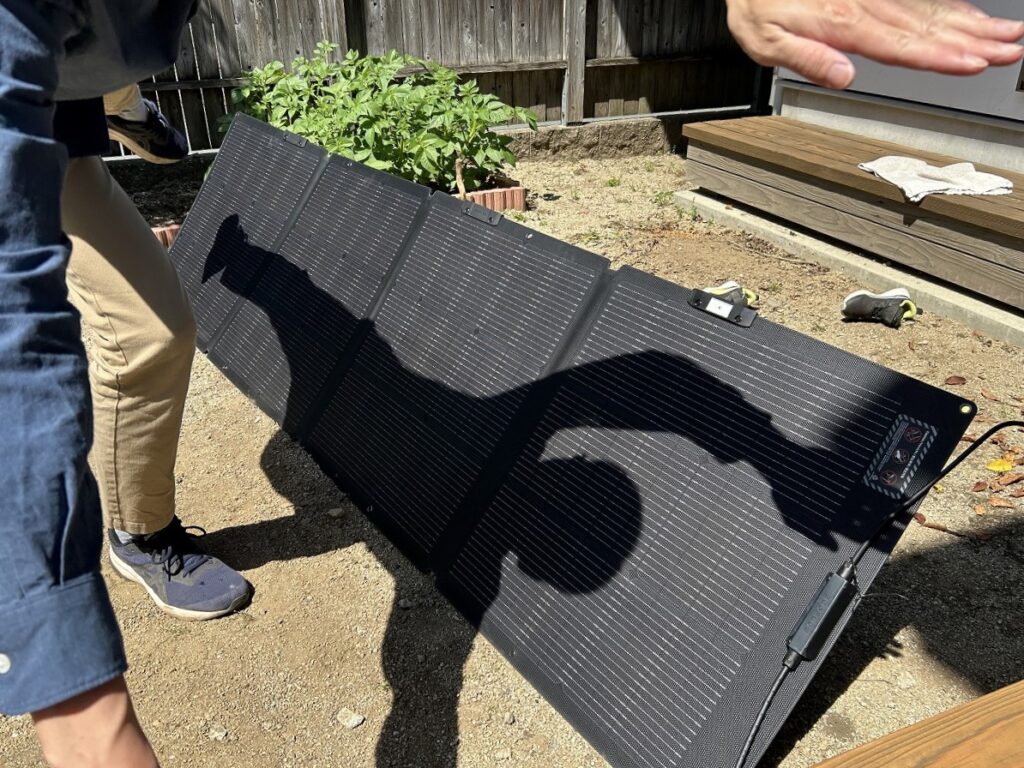 大人がパネルに日陰を作り充電効率を確認する実験風景