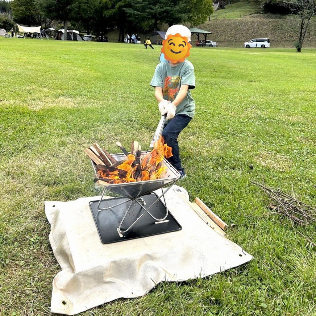 服掛松キャンプ場で昼の焚き火を楽しむ子供