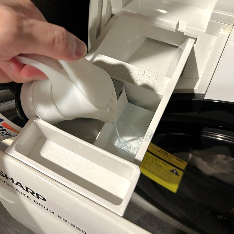 洗剤を洗濯乾燥機に投入する様子